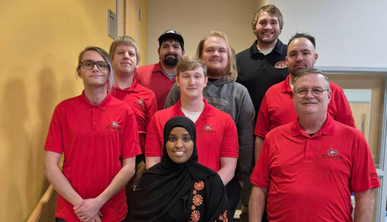 "St. Cloud State cybersecurity contest victory symbolized by a team managing mock networks, tackling cyberattacks, and excelling under pressure."