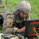 **Alt Text:** "A soldier monitoring network security data on a digital interface, illustrating the Army's use of zero trust cybersecurity tools to counter cyber threats."