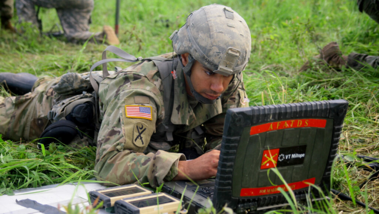 **Alt Text:** "A soldier monitoring network security data on a digital interface, illustrating the Army's use of zero trust cybersecurity tools to counter cyber threats."